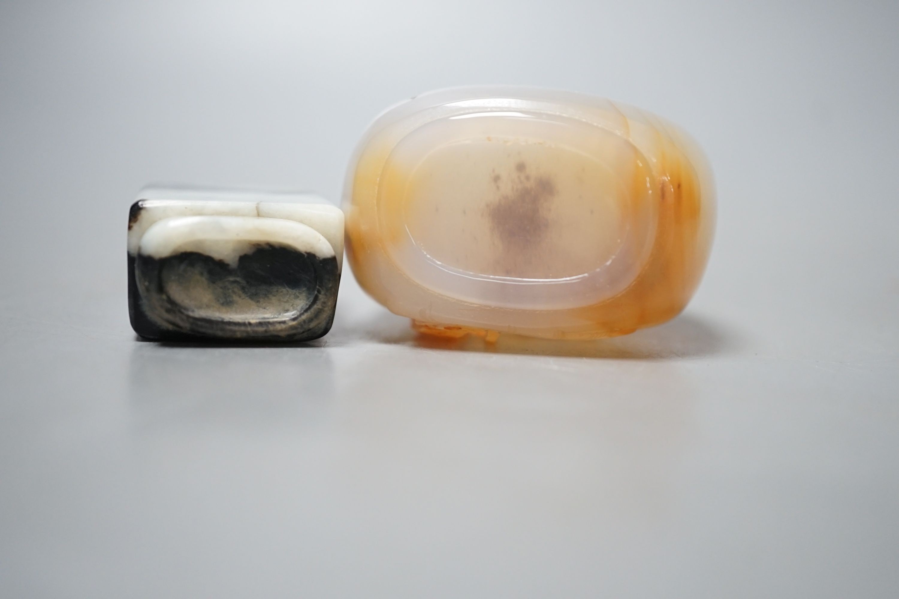 A Chinese white and black jade snuff bottle and a similar agate snuff bottle